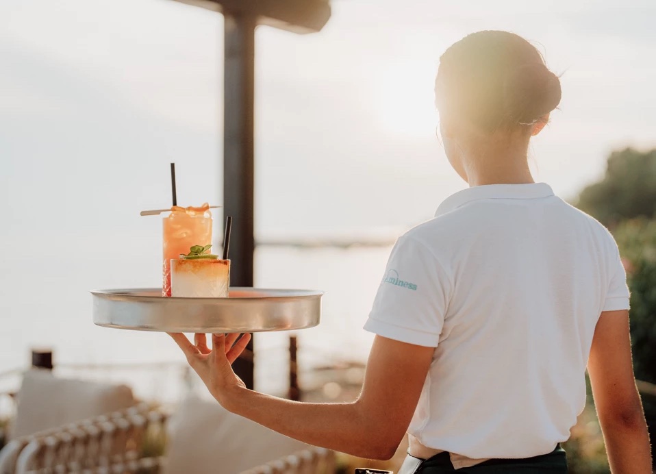 Waiter carrying drinks by the sea